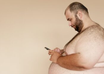 Topless Man Using Black Cellphone