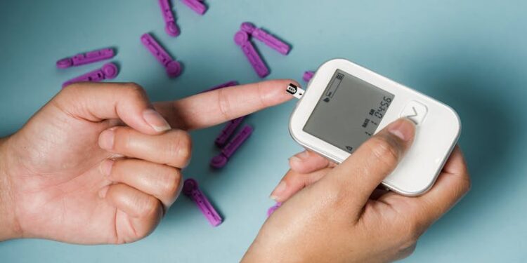 From above of crop anonymous female diabetic using electronic tool for controlling blood sugar above lancets
