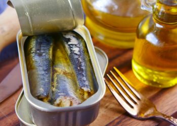a tin of sardines sitting on top of a wooden table