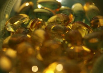 a glass bowl filled with lots of yellow and green pills