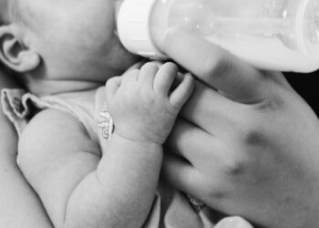grayscale photo of baby feeding