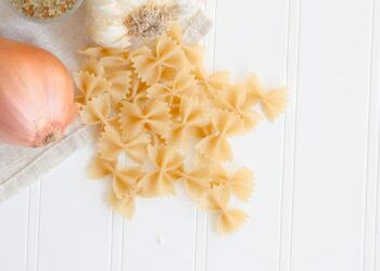 ribbon pasta beside garlic and onion