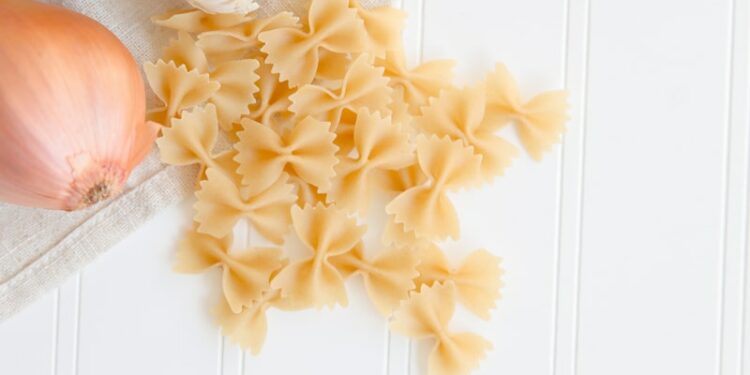 ribbon pasta beside garlic and onion