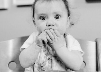 Black and White Portrait of Baby Making Mess while Eating