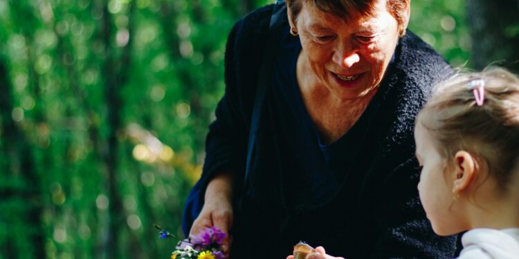 woman in black long sleeve shirt holding purple flower