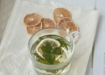 A cup of tea with lemon slices and mint