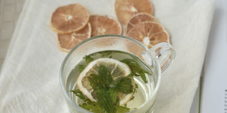 A cup of tea with lemon slices and mint