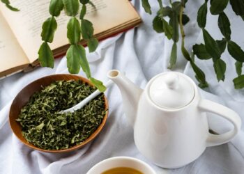 a cup of tea next to a bowl of tea and a book
