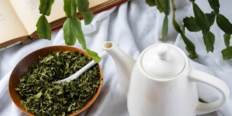 a cup of tea next to a bowl of tea and a book