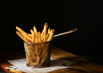 a basket of french fries sitting on top of a wooden table