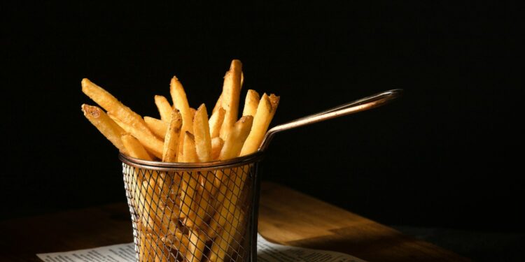a basket of french fries sitting on top of a wooden table