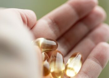 A person holding a handful of pills in their hand