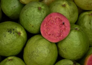a pile of green and red fruit sitting on top of each other