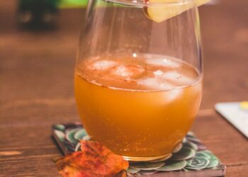 clear drinking glass with brown liquid and lemon