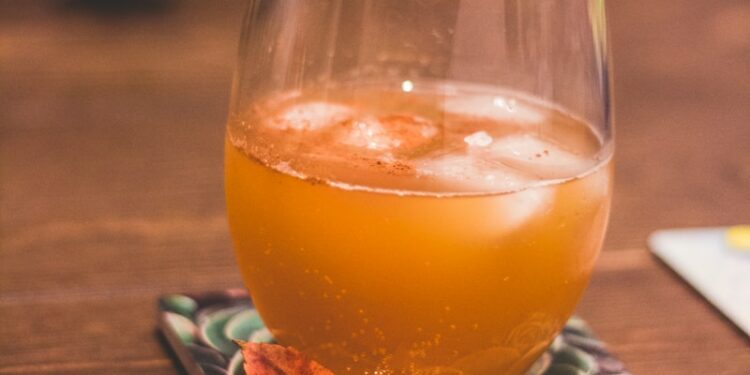 clear drinking glass with brown liquid and lemon