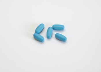 a group of blue pills sitting on top of a white table