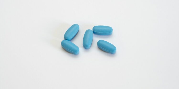 a group of blue pills sitting on top of a white table