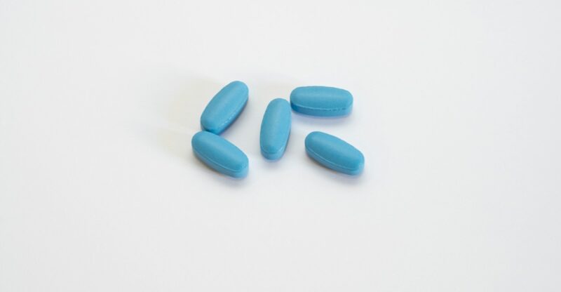 a group of blue pills sitting on top of a white table