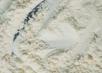 Flour is being scraped with a utensil.