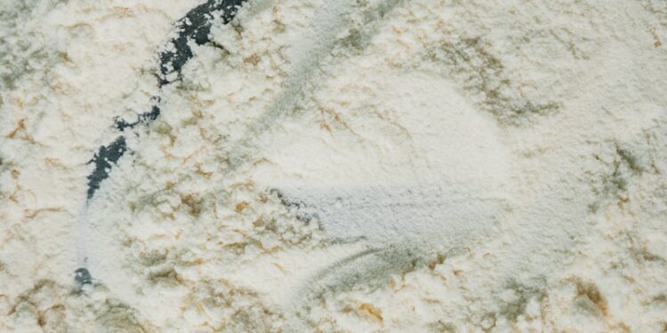 Flour is being scraped with a utensil.