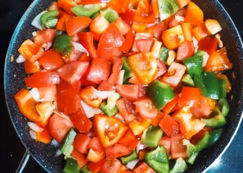 Chopped vegetables cooking in a pan.