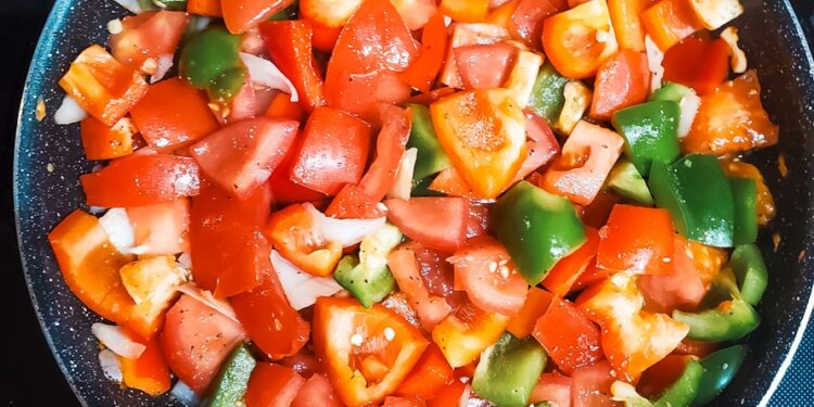 Chopped vegetables cooking in a pan.