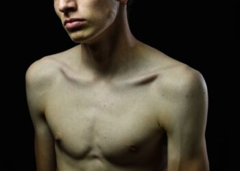 topless man with eyebrow piercing