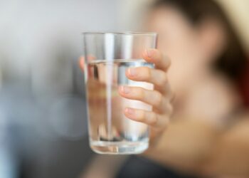 person holding clear drinking glass