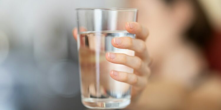 person holding clear drinking glass