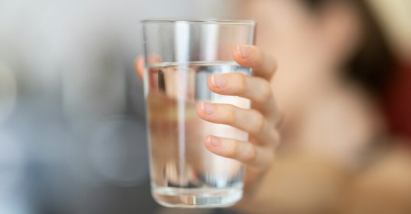 person holding clear drinking glass