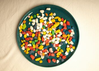 A green plate filled with candy corn on top of a white table