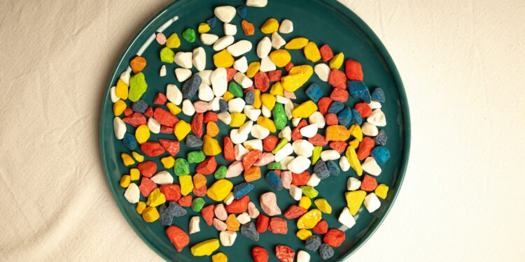 A green plate filled with candy corn on top of a white table