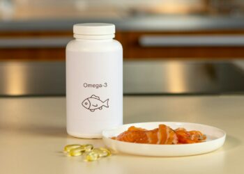 a bowl of fish next to a bottle of vitamins