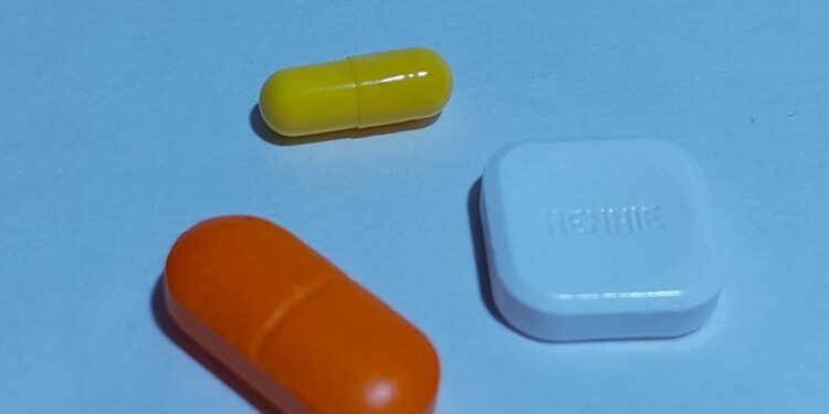 A group of three pills sitting next to each other