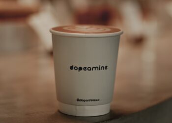 a white cup with a brown lid