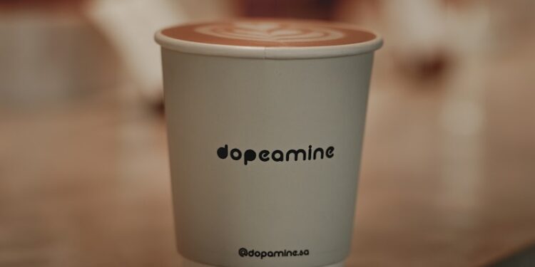 a white cup with a brown lid