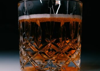 A glass filled with liquid sitting on top of a table