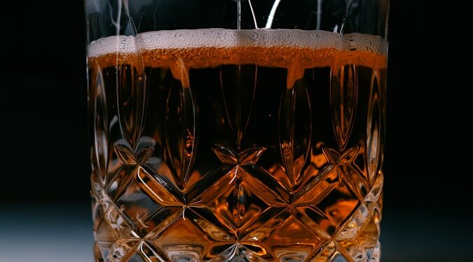 A glass filled with liquid sitting on top of a table
