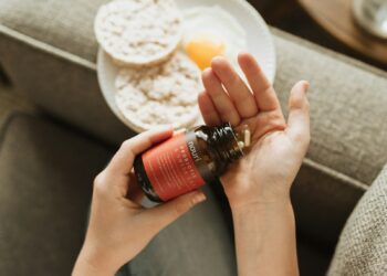 person holding red bottle
