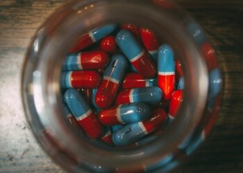 a glass jar filled with red and blue pills
