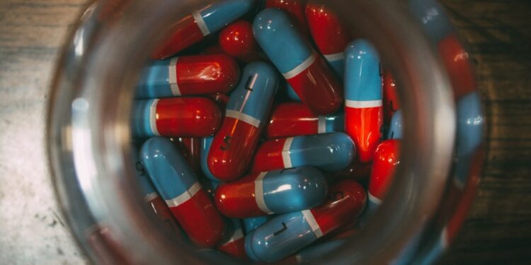 a glass jar filled with red and blue pills
