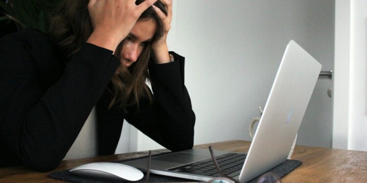 a woman sitting in front of a laptop computer