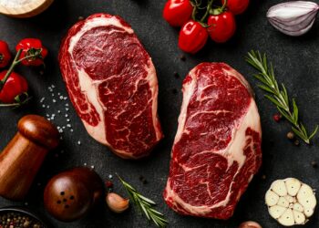 a couple of steaks sitting on top of a table