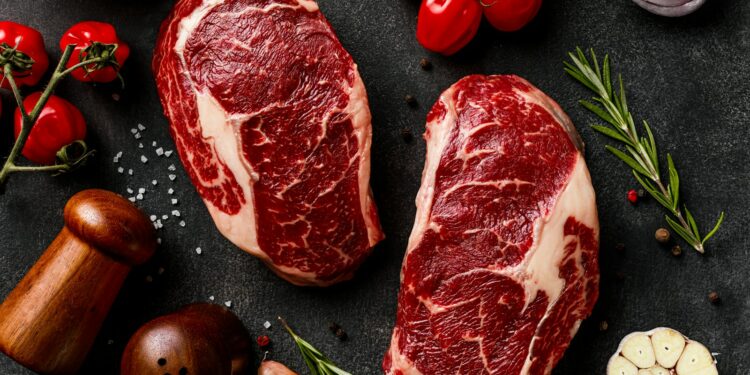 a couple of steaks sitting on top of a table