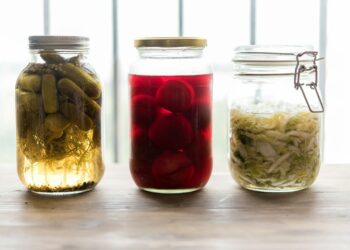 three jars filled with different types of food