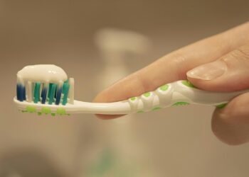 a person is holding a toothbrush with toothpaste on it