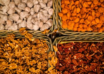 A bunch of baskets filled with different types of nuts