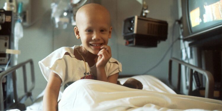 child sitting on bed
