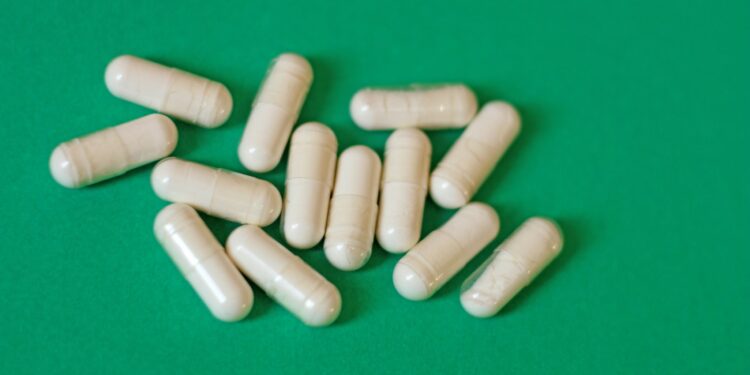 A pile of pills sitting on top of a green table