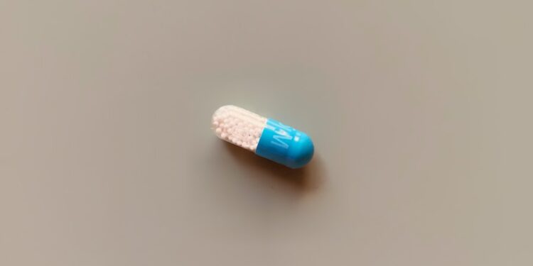 a blue and white pill sitting on top of a table